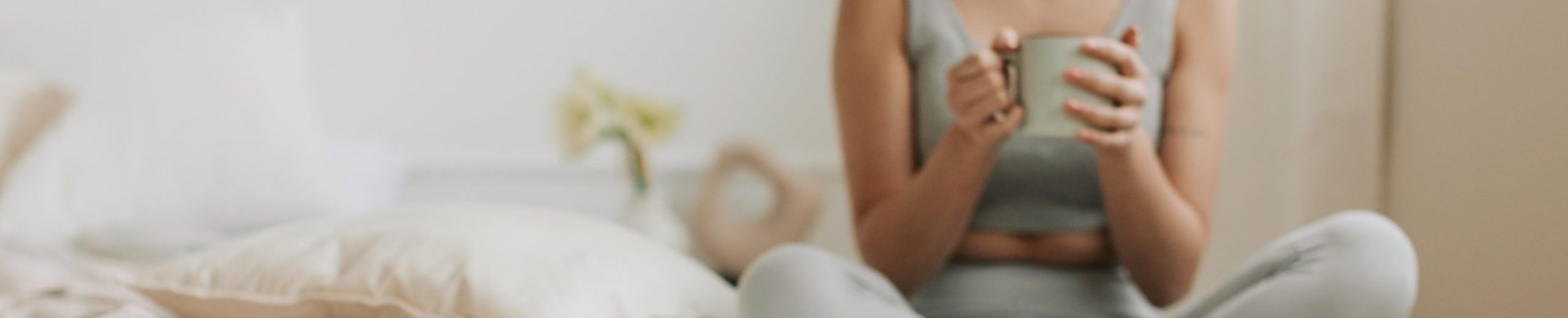 Person sitzend mit einem heißen Getränk in den Händen